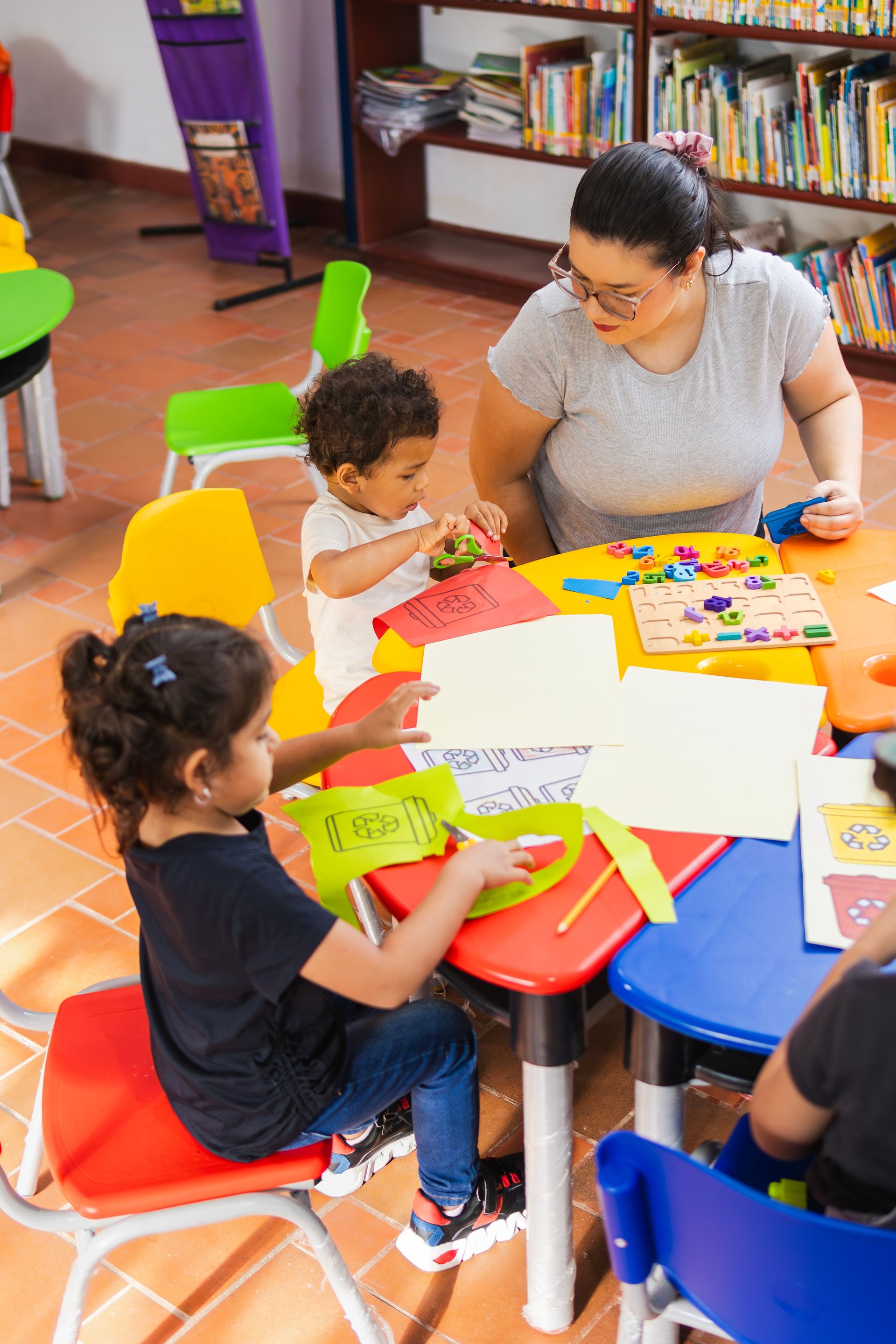 Children learning recycling activities with teacher in kindergarten